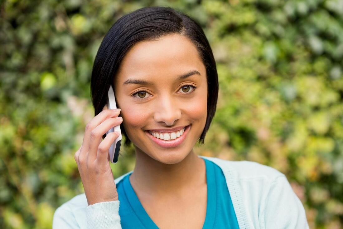 girl smiling while talking to her phone 