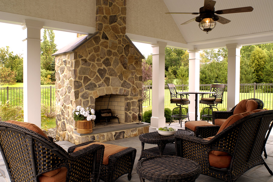 covered patio with chimney and comfortable chairs
